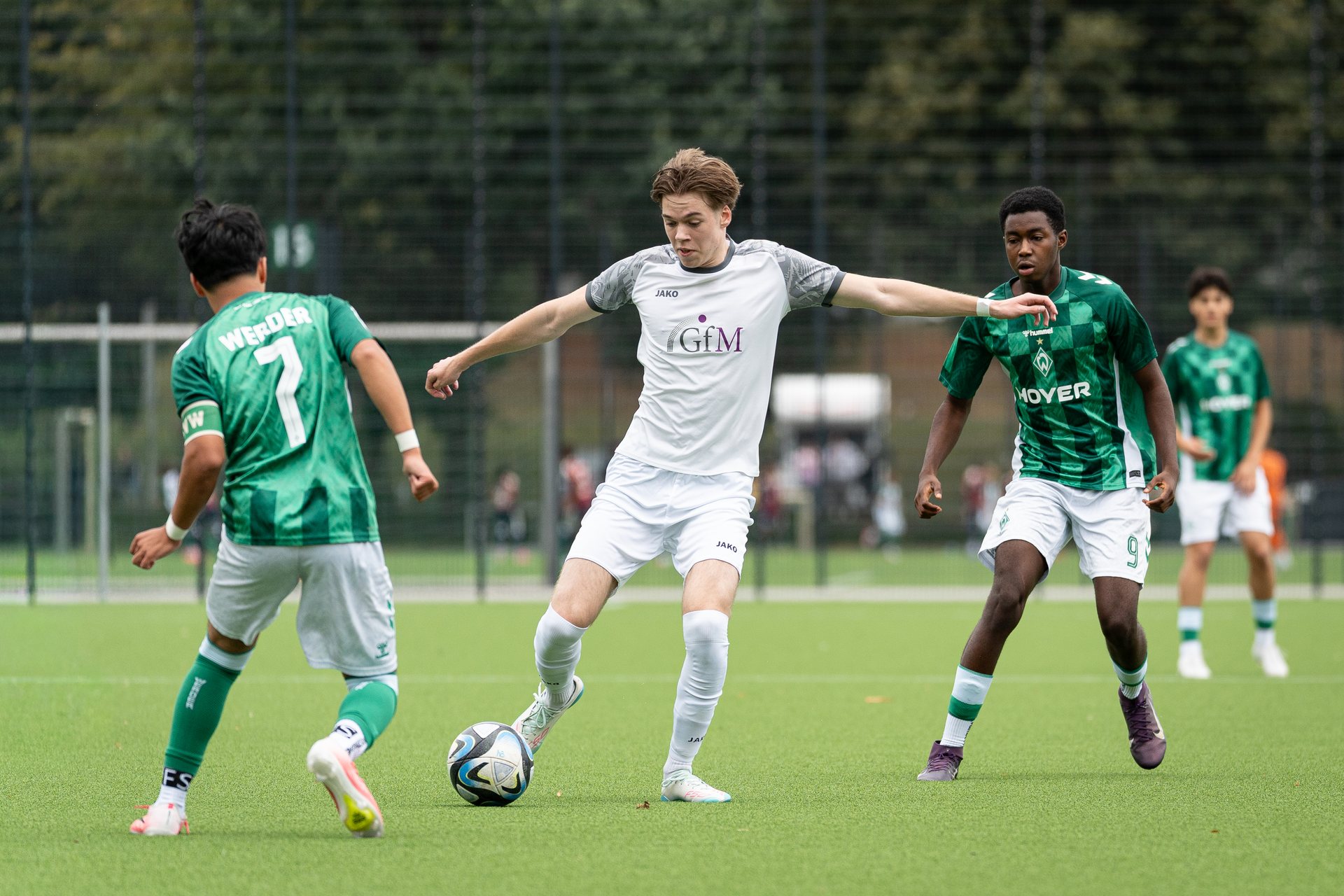 Spieler des SV Grohn am Ball zwischen zwei Spielern von SV Werder Bremen III