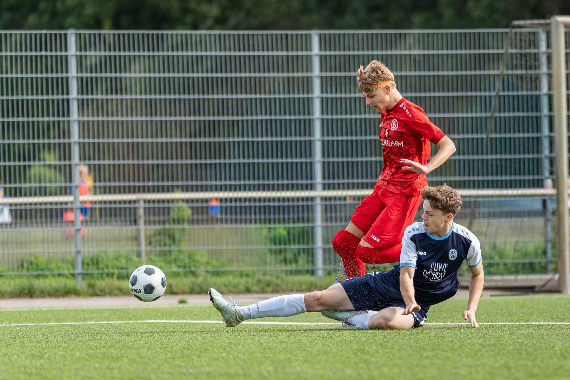Spieler des Habenhauser FV grätscht neben einem Spieler von ATS Buntentor zum Ball