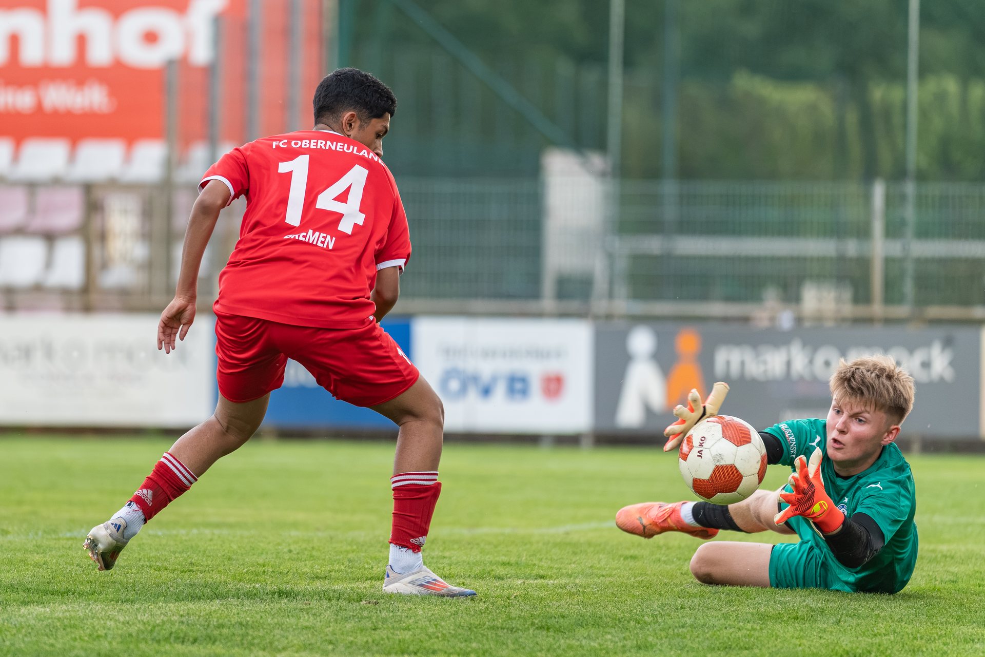 Torhüter des Habenhauser FV wehrt den Ball vor einem Spieler des FC Oberneuland ab