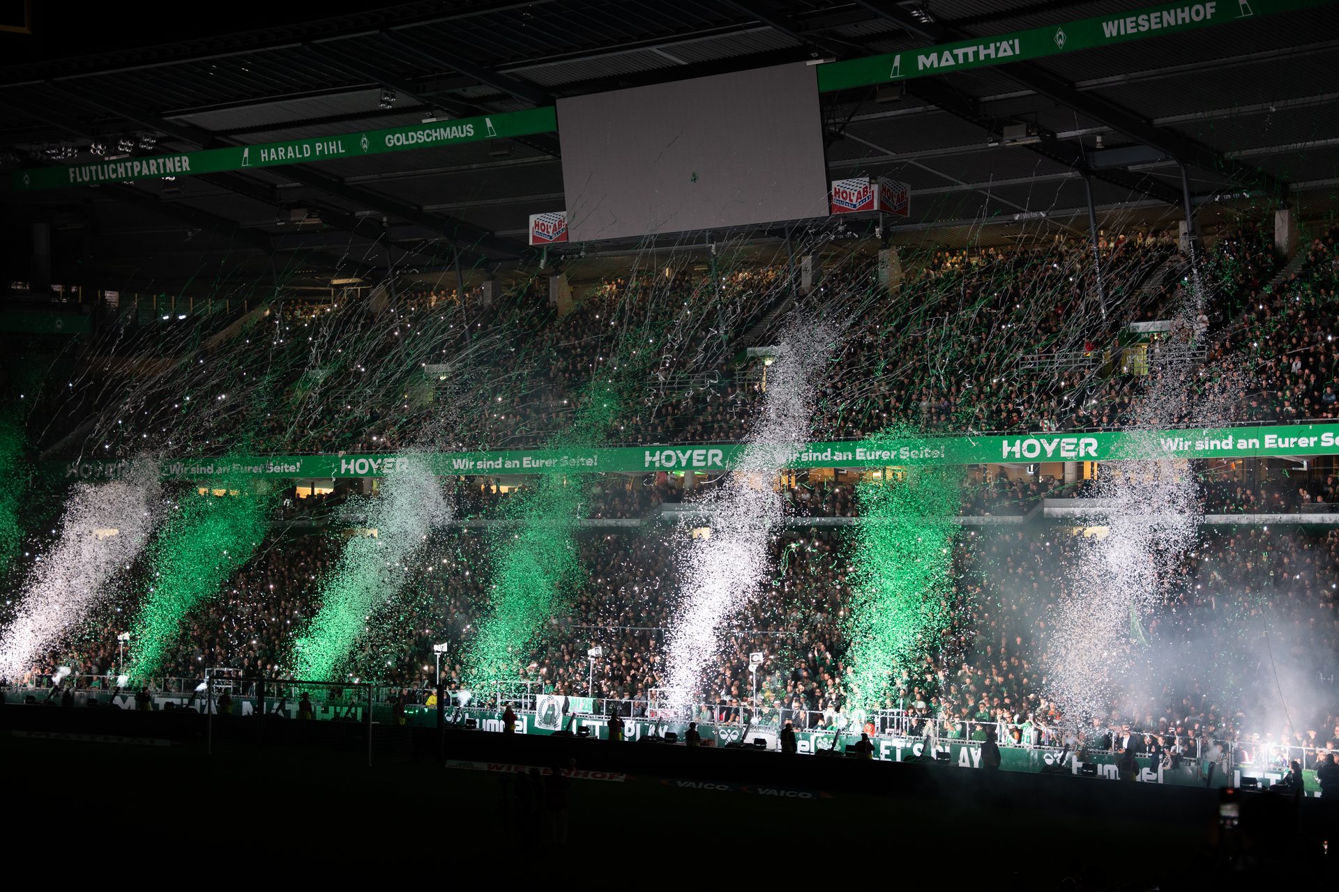 Grün-weiße Fankurve mit Konfetti unter dem Stadiondach