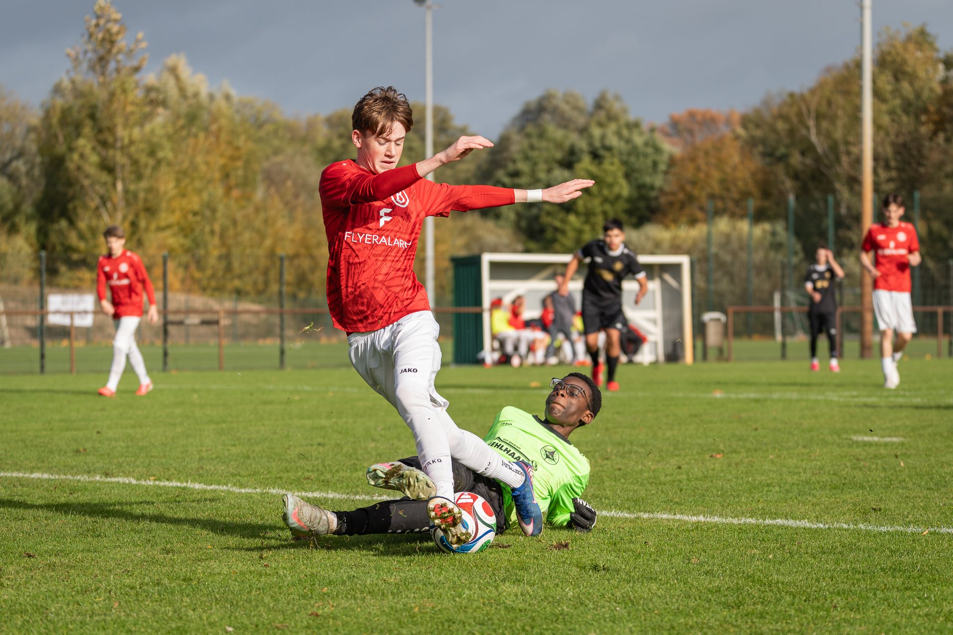 Torhüter vom 1.FC Burg wirft sich im Strafraum vor einen Angreifer von ATS Buntentor nach dem Ball