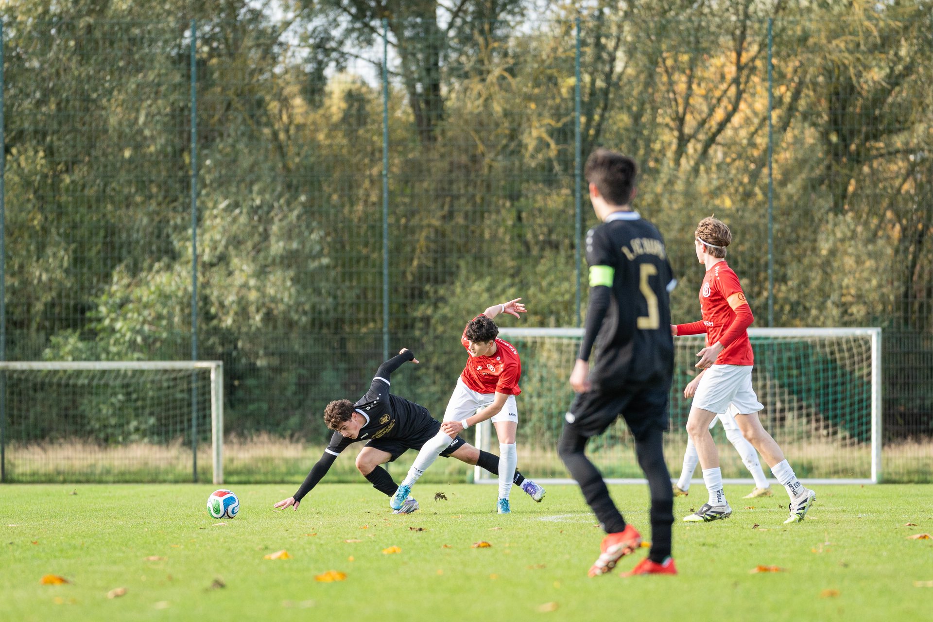 Spieler vom 1.FC Burg stürzt im Zweikampf mit einem Spieler von ATS Buntentor vor dem Tor