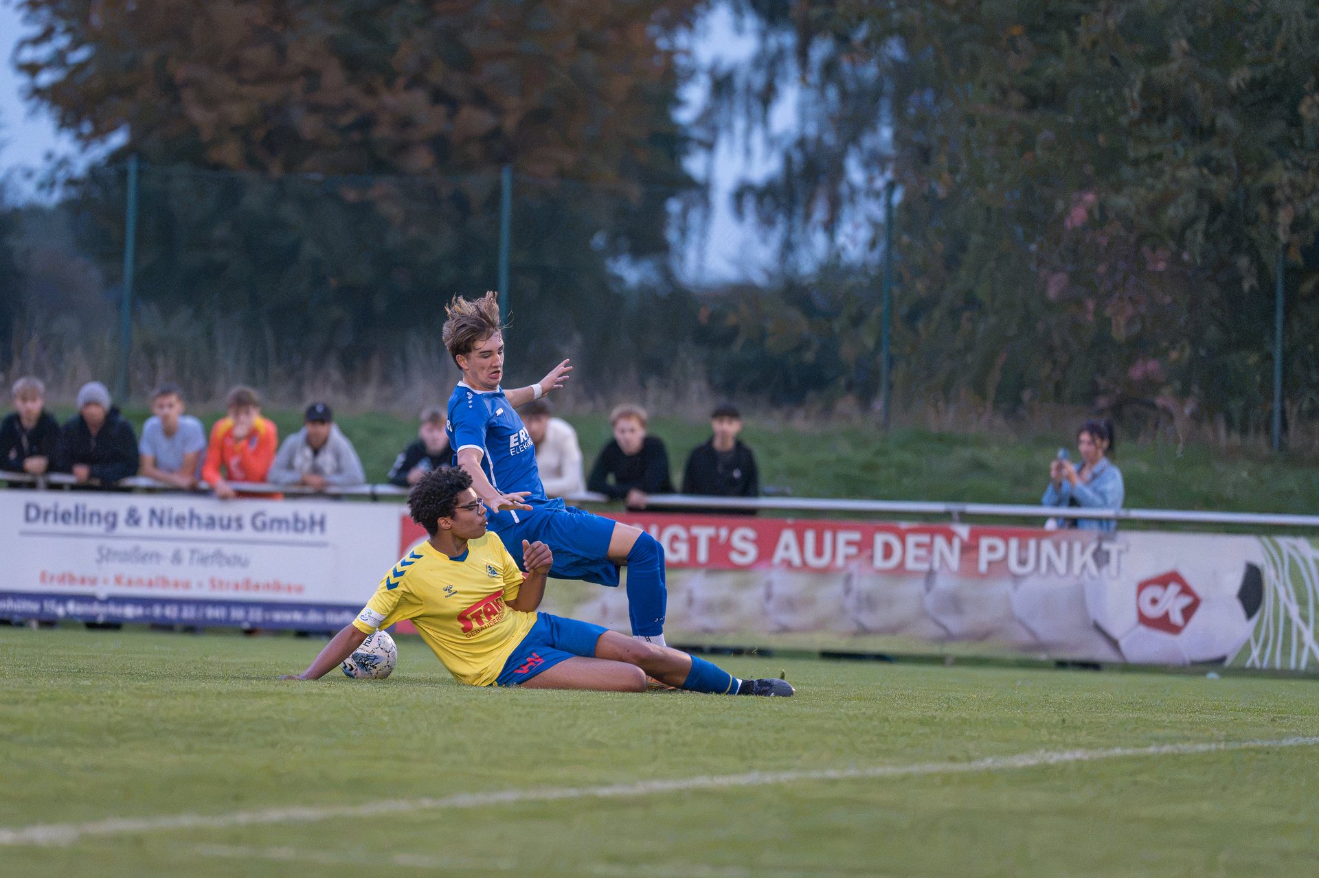 Spieler in gelben und blauen Trikots im Zweikampf um den Ball