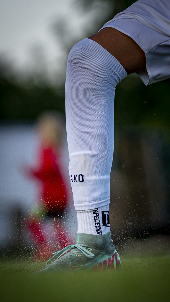 Fussballschuh tritt energisch auf Kunstrasen – Sportbild aus der Region Bremen