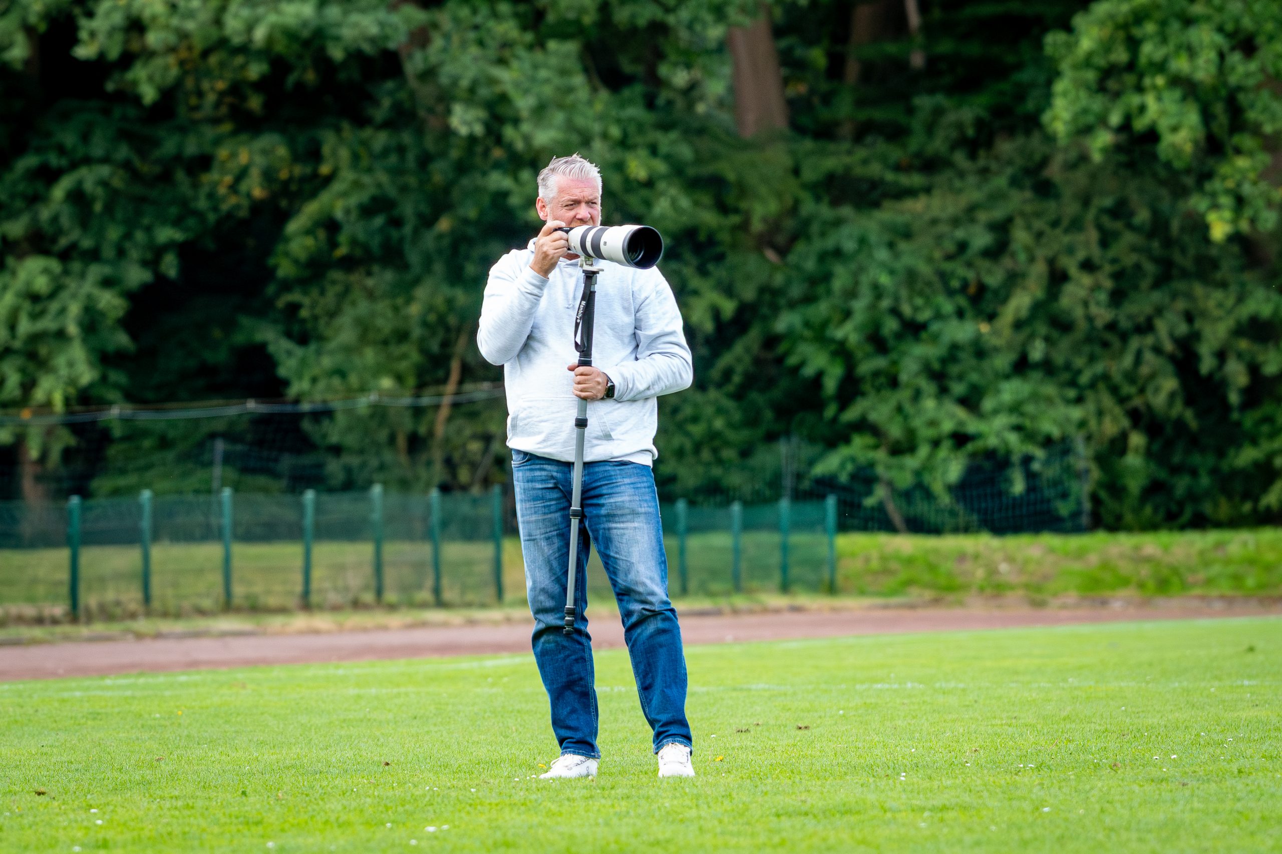 Sportfotograf Torben Jeske von Blr.Pics steht auf dem Spielfeld und macht Fotos